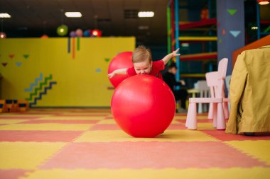 Gülen çocuk 1-2 yaşında, çocuk parkında ve oyun merkezinde doğum günü partisinde top havuzunda eğleniyor. Çocuk oyun parkında renkli toplarla oynuyor. Küçük çocuk için oyuncaklar.