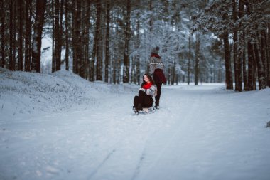İki genç yeniyetme kız arkadaş bir arada. İki kız kardeşin moda portresini yakın çekin. Kışları eğlenin, süveter giyin, en iyi arkadaşlar açık havada, karlı havada.