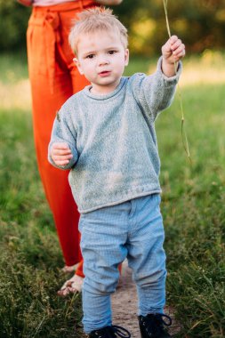 Erkek bebek 1-2 yaşında yazın doğayı keşfediyor, eğleniyor.