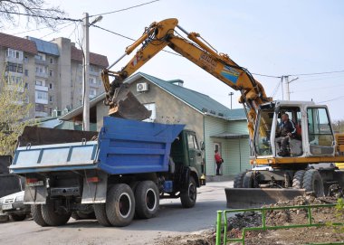 Ekskavatör taş kazılar ve kamyona dökülen