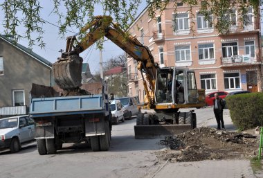 Ekskavatör taş kazılar ve kamyona dökülen