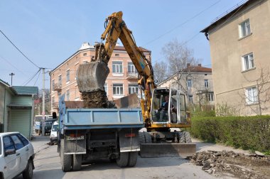 Ekskavatör taş kazılar ve kamyona dökülen