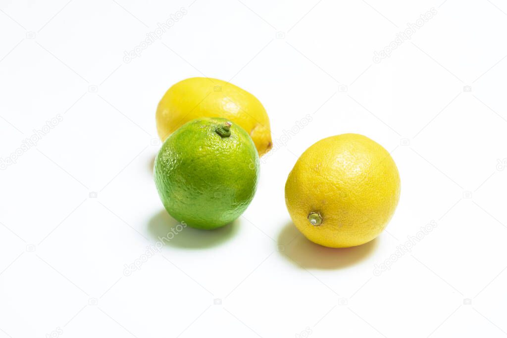 Yellow and green lemons on white background