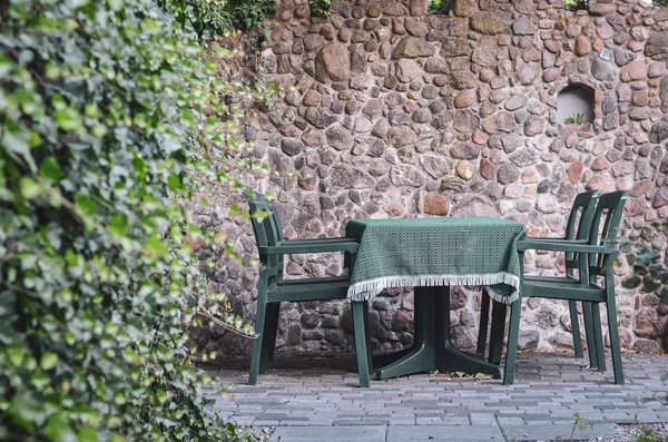 Grönt Bord Och Stolar Bakgrunden Stenvägg Mysig Uteservering — Stockfoto