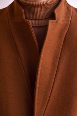 Modaya uygun erkek kahverengi paltosu ve kahverengi moda süveter yakın çekim. Düşük Dof. 