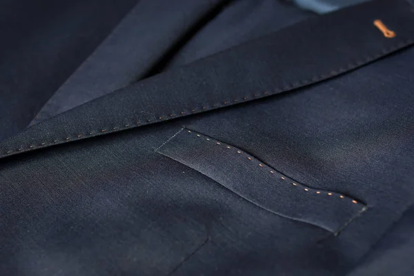 Dark blue formal suit with a pocket fragment for background. Selective focus.