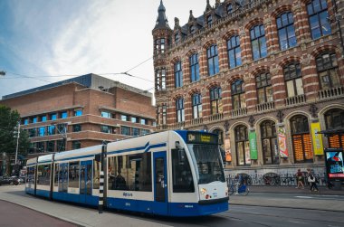 Amsterdam 'ın orta caddelerinde modern tramvaylar. Geleneksel şehir görünümü. 