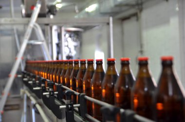 Glass bottles in row on the conveyor belt. Selective focus.