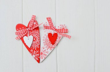 Red and white handmade hearts on white background. Copy space.