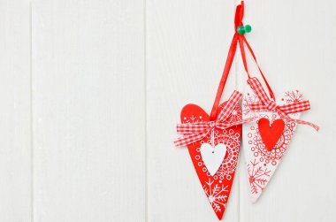 Red and white handmade hearts on white background. Copy space.