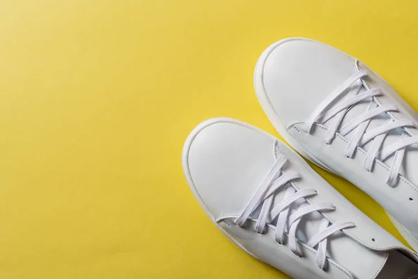 Par Zapatillas Cuero Blanco Sobre Vibrante Fondo Amarillo Copiar Espacio — Foto de Stock