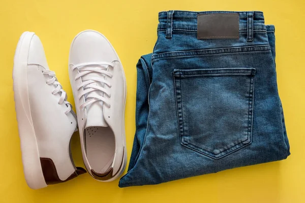 Uppsättning Vita Sneakers Och Blå Jeans Gul Bakgrund — Stockfoto