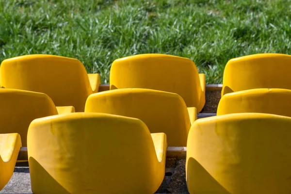 Żółte Plastikowe Siedzenia Zielona Trawa Stadionie — Zdjęcie stockowe