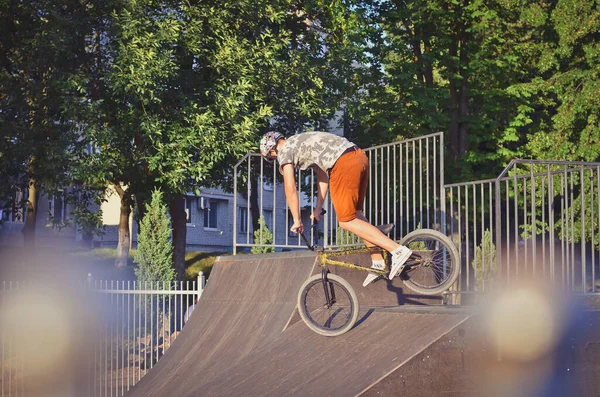 BMX biker is making stunts in the extreme skating park.