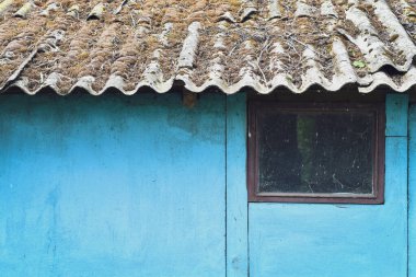 Penceresi olan eski bir kulübenin mavi eskimiş ahşap dokusu. Seçici odak. 