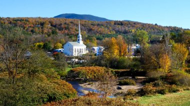 Stowe 'daki sonbahar yeşillikleriyle kaplı bir kilisenin geniş bir görüntüsü.