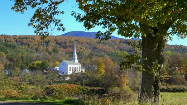 Fehér templom stowe keretezett fa és egy hegy őszi lombozat — Stock Fotó