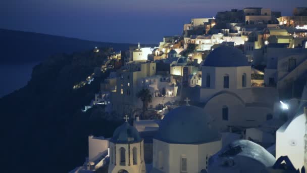 オイア、サントリーニ島の夜に3つの青いドームの広い眺め — ストック動画