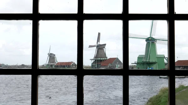 AMSTERDAM, NEDERLÄNDERNA-OKTOBER, 12, 2017: väderkvarnar sett genom ett fönster vid zaanse schans nära Amsterdam — Stockfoto