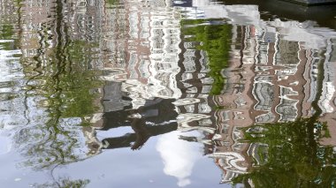Bir amfi kanalının suyuna yansıyan binaların soyut bir görüntüsü