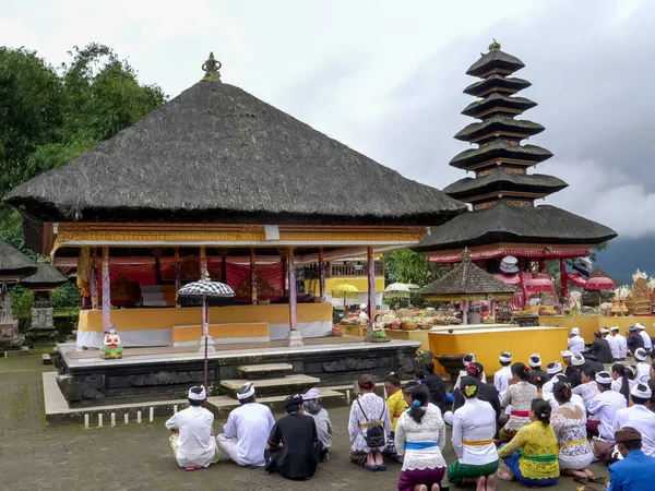 BEDUGUL, INDONÉSIA MARÇO, 15, 2018: adoradores hindus sentam-se em um pátio do templo pura danu bratan em bali — Fotografia de Stock