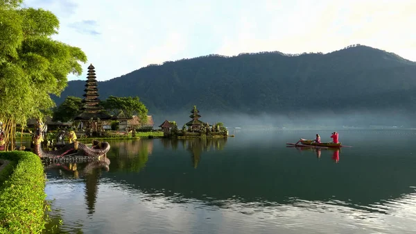 Turistas en una canoa fotografía pura danu bratan templo en la isla de bali — Foto de Stock