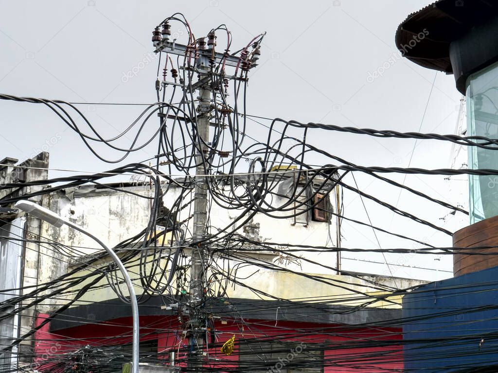 a maze of power lines above the streets of kuta in bali