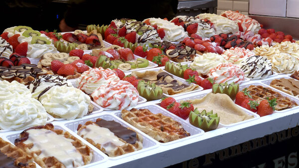 side view of a variety of fresh belgian waffles on display in brussels