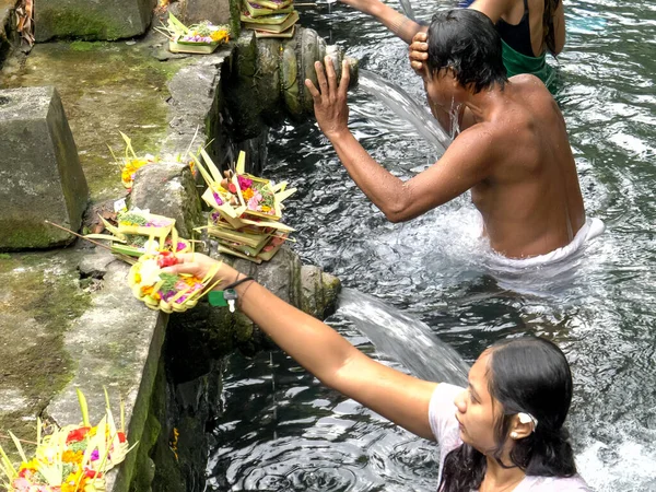 MANUélia, INDONÉSIA- MARÇO, 22, 2018: mulher hindu coloca oferta no templo de água benta em bali — Fotografia de Stock