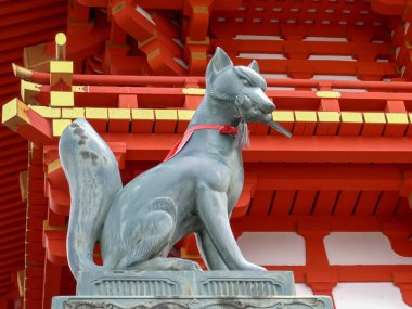 KYOTO, JAPONYA - 16, 2018: Fushimi inari türbesindeki bir tapınağın önündeki tilki heykelinin yan görüntüsü