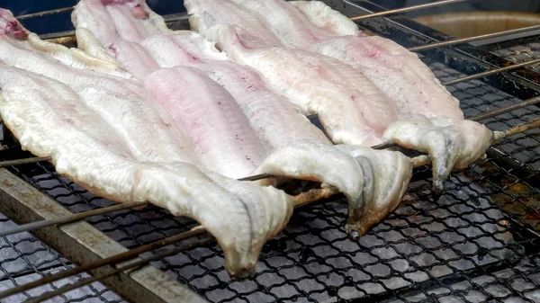 Крупным планом рыбы, которую готовит на гриле продавец за пределами храма Фушими Инари — стоковое фото
