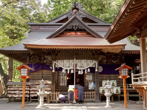 two japanese worshipers at arakura sengen shrine in japan