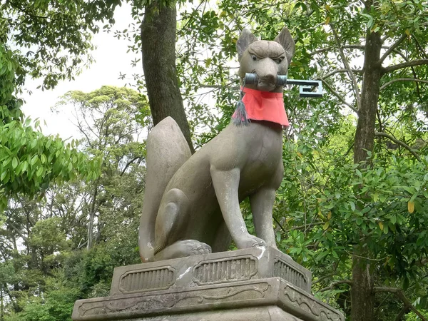 Låg vinkel skott av en räv som håller en nyckel vid fushimi inari helgedom — Stockfoto