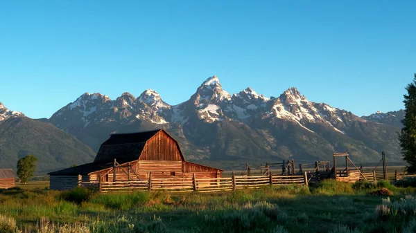 Tiro de um celeiro e grande teton ao nascer do sol em wyoming — Fotografia de Stock