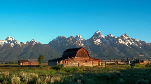 Nascer do sol tiro largo de um celeiro de linha mórmon e grande montanha teton — Fotografia de Stock