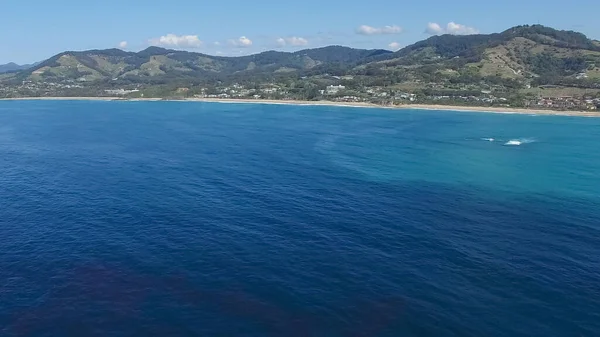Tiro aéreo volando hacia la playa de zafiro en el puerto de Coffs —  Fotos de Stock