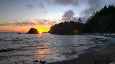 sunset shot of waves on the shore at rialto beach in the olympic national park clipart
