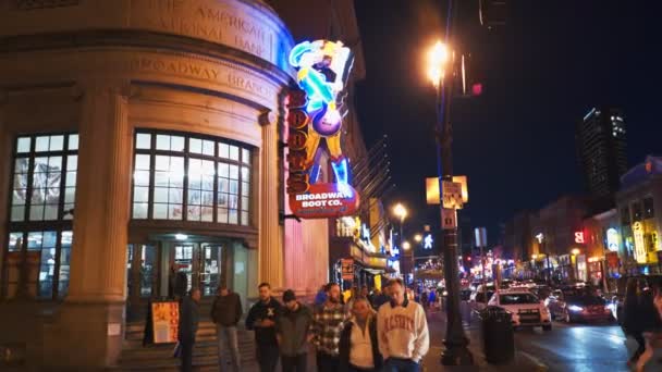 NASHVILLE, USA -April, 6, 2017: promenader tvärs över gatan mot en neonskylt i nashville, tn — Stockvideo