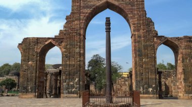 Qutub Minar 'daki demir sütuna doğru bakıyor.