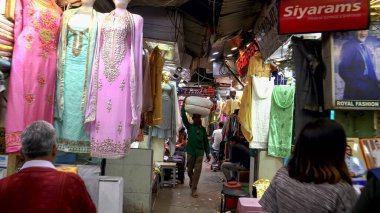 DELHI, Hindistan - 12 Mart 2019: Eski Delhi 'de sari satan mağazaların önünden geçmek