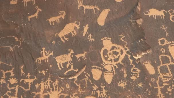Zoom avant sur un dessin d'une figure humaine à cheval chassant des moutons à la roche du journal dans le parc national des Canyonlands — Video