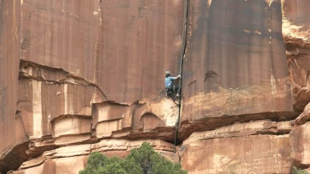 MOAB, ABD - 27 Mart 2017: Canyonlands, Utah 'ta kaya tepesine tırmanan kadın dağcı — Stok video