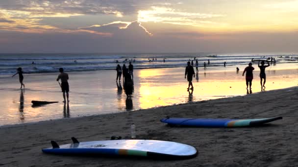 Playa chico llevar longboard al atardecer en kuta, bali — Vídeo de stock