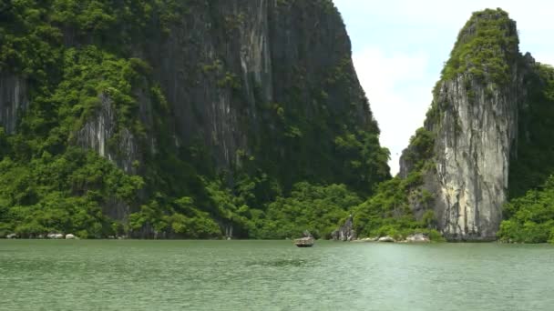 Lang schot van een vissersboot en verschillende bergtoppen van de Halong baai — Stockvideo