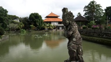 Taman Ayun tapınağında geniş bir heykel ve hendek görüntüsü.