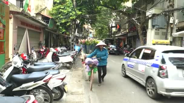 HANOI, VIETNAM - 28. června 2017: žena tlačí kolo s květinami ve staré čtvrti Hanoje — Stock video