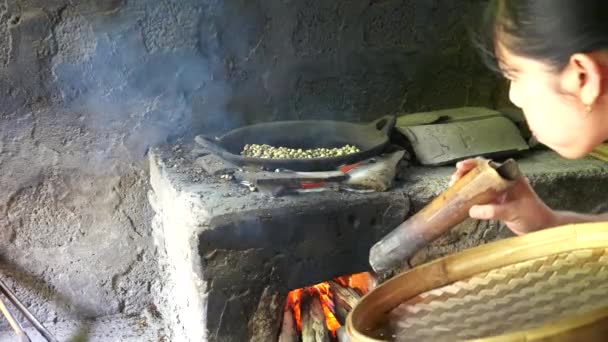 ДЕНПАСАР, ИНДОНЕЗИЯ - 16 июня 2017 года: обжаривание кофейных зерен на костре в кафе на Бали — стоковое видео