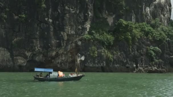 Egy vietnámi halászhajó mellett vitorlázok a Halong öbölben. — Stock videók