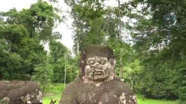 Angkor Wat yakınlarındaki Preah Khan Tapınağı 'ndaki geçitte bir heykelin aşağı eğilmiş görüntüsü.
