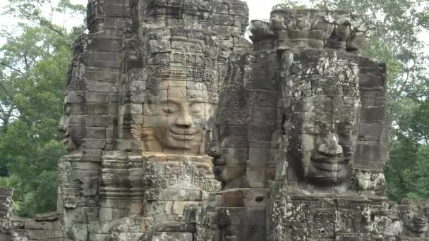 Pan of four large stone faces at bayon temple — Stock Video